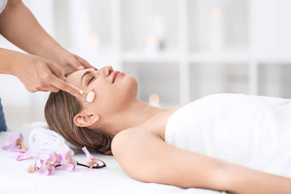 Mooie jonge vrouw gezicht massage in de spa salon ontvangen — Stockfoto