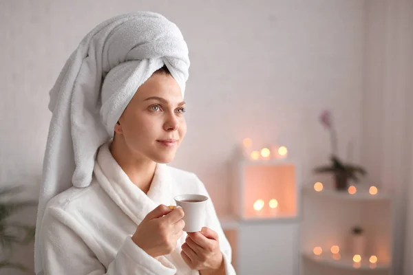 Beautiful young woman with cup of tea relaxing in spa salon — Stock Photo, Image
