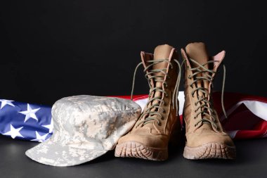 Askeri botlar, şapka ve abd bayrağı koyu arka planda