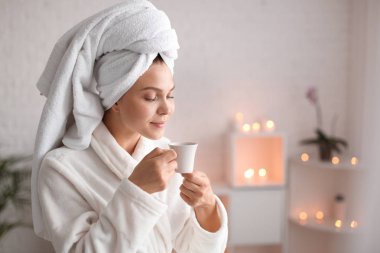 Spa salonunda rahatlatıcı çay fincan ile güzel genç kadın