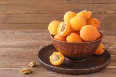 Ahşap masa üzerinde lezzetli olgun kayısı ile Bowl