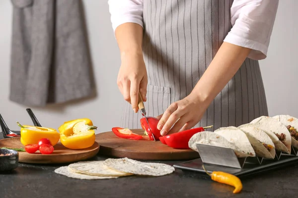 Mujer preparando sabrosos tacos frescos en la cocina — Foto de Stock