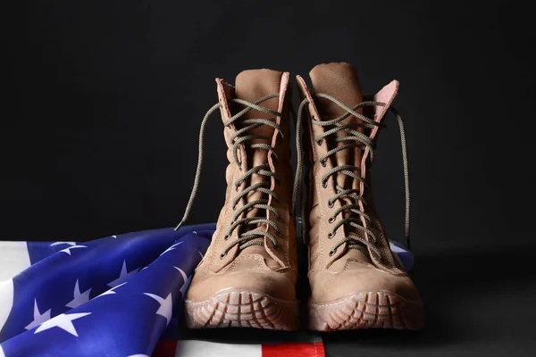 Vojenská obuv a vlajka USA na tmavém pozadí — Stock fotografie
