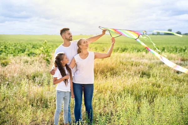 Happy family flying kite in field — Stock Photo, Image