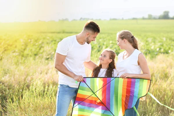 Lycklig familj med kite i fält — Stockfoto