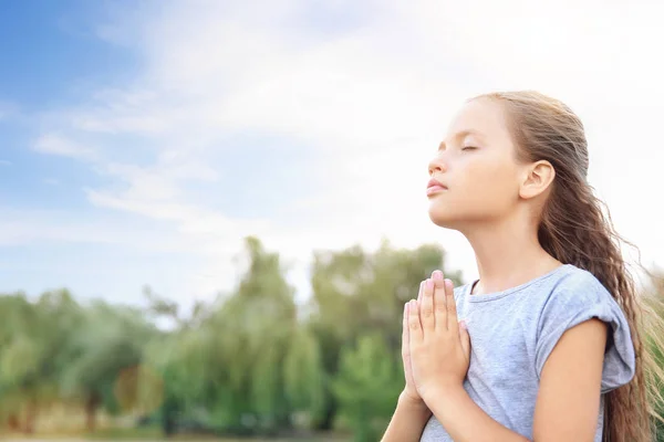 Το μικρό κορίτσι προσεύχεται στο Θεό σε εξωτερικούς χώρους — Φωτογραφία Αρχείου