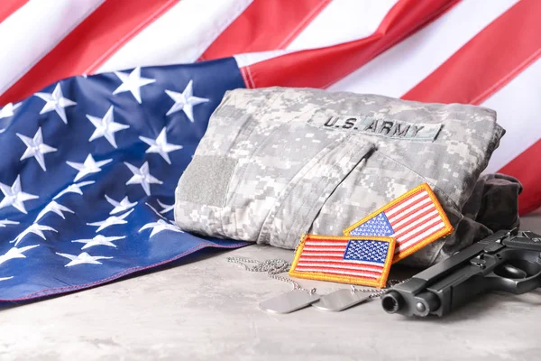 Военная форма, оружие и флаг США на столе — стоковое фото
