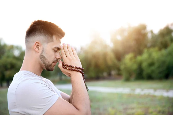 Young man praying to God outdoors — Stock Photo, Image