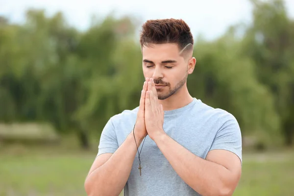 Young man praying to God outdoors — Stock Photo, Image