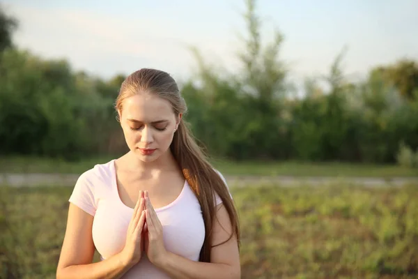 Młoda kobieta modląca się do Boga na zewnątrz — Zdjęcie stockowe