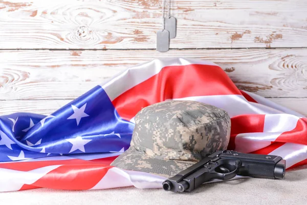 テーブルの上の軍帽、銃とアメリカの旗 — ストック写真