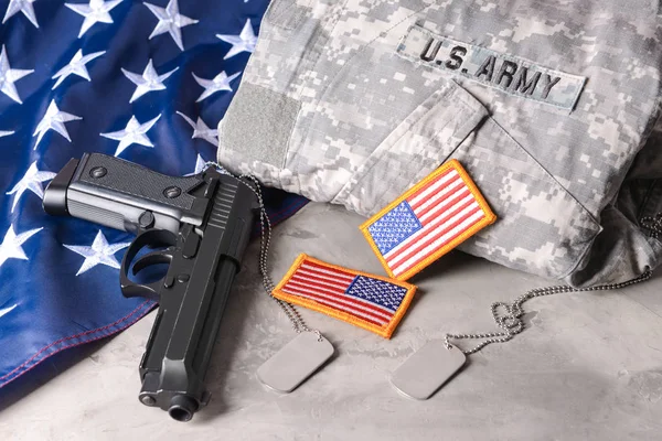 Military uniform, gun and USA flag on table