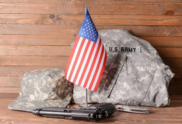 Military uniform, gun and USA flag on wooden table — Stock Photo, Image