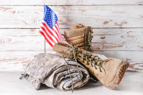 Military uniform and USA flag on table against wooden background — Stock Photo, Image