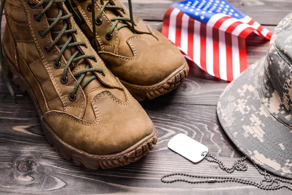 Vojenské boty, vlajka USA, čepice a psí značka na dřevěném pozadí — Stock fotografie