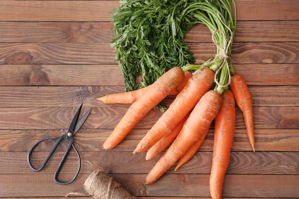 Bunch of carrots on wooden table — Stock Photo, Image