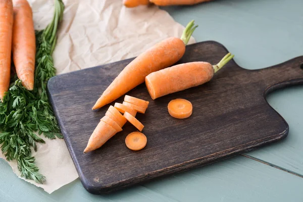 Papan potong dengan wortel segar di atas meja — Stok Foto