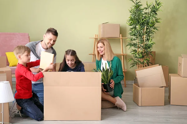 Família feliz desempacotando pertences em sua nova casa — Fotografia de Stock