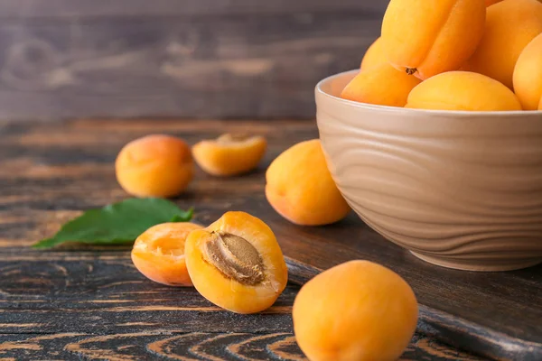 Миска зі смачними стиглими абрикосами на дерев'яному столі — стокове фото