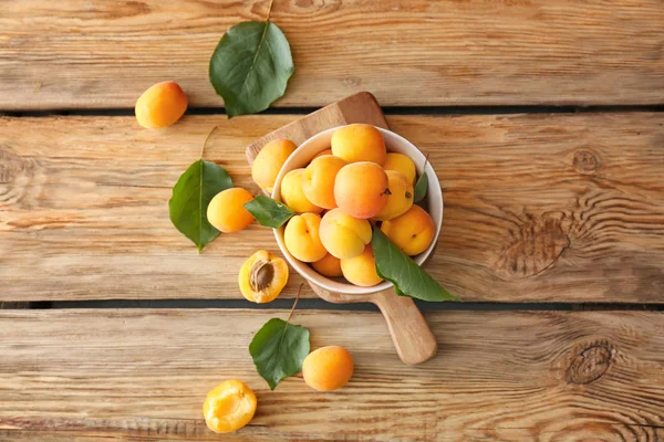 Bowl with tasty ripe apricots on wooden table — Stock Photo, Image