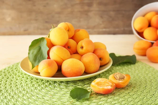 Plate with tasty ripe apricots on table — Stock Photo, Image