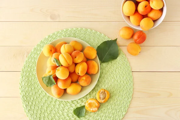 Plate with tasty ripe apricots on wooden table — Stock Photo, Image