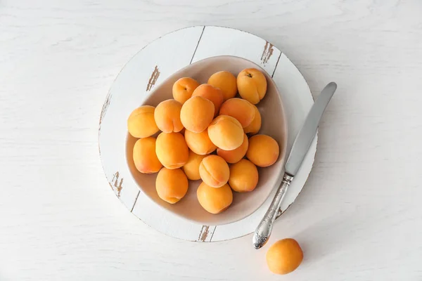 Bord met smakelijke rijpe abrikozen op witte houten tafel — Stockfoto