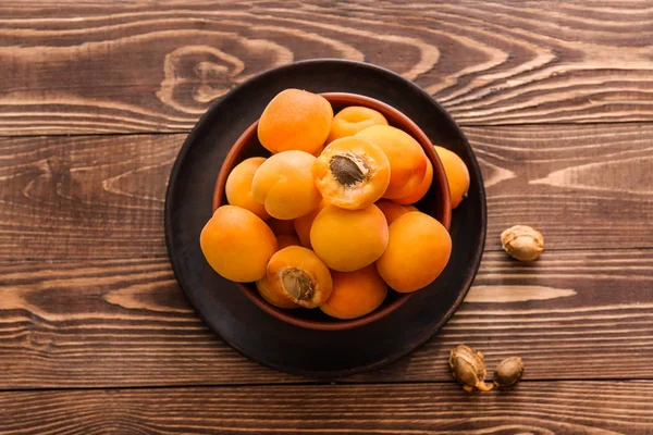 Ahşap masa üzerinde lezzetli olgun kayısı ile Bowl