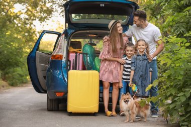 Açık havada paketlenmiş bagaj ile araba yakınında Mutlu aile