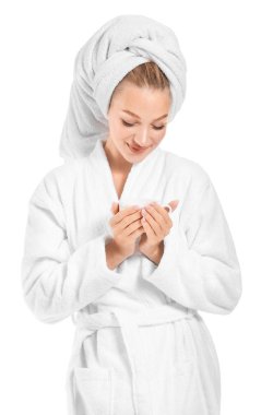 Beyaz arka planda kahve içen bornoz güzel genç kadın