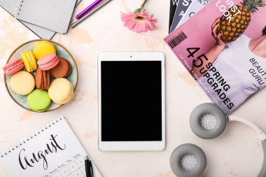 Modern tablet bilgisayar, dergiler, makaronlar, takvim ve kulaklıklar masada