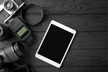 Tablet bilgisayar ve koyu ahşap arka plan üzerinde fotoğrafçının ekipman seti