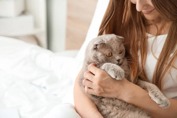 Mulher bonita com gato bonito sentado na cama em casa — Fotografia de Stock