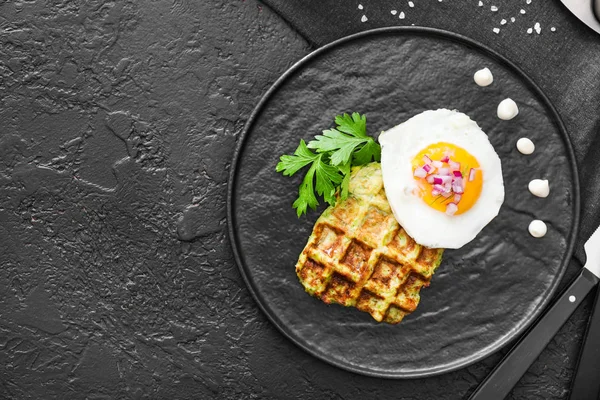 Plate with tasty squash waffle and fried egg on dark table — Stock Photo, Image