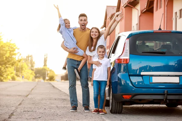 Família feliz perto de carro ao ar livre — Fotografia de Stock