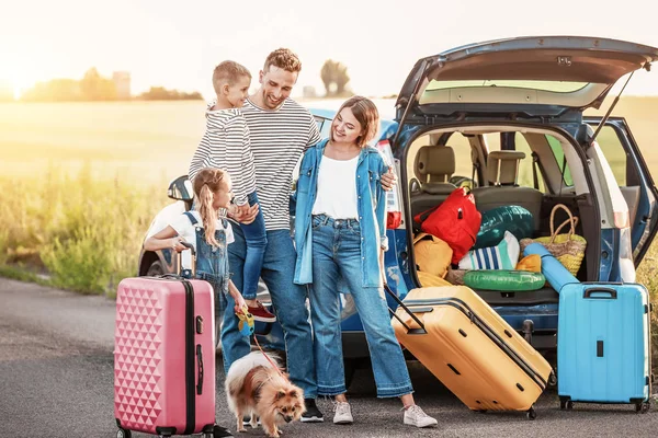 Szczęśliwa rodzina z bagażem w pobliżu samochodu na zewnątrz — Zdjęcie stockowe