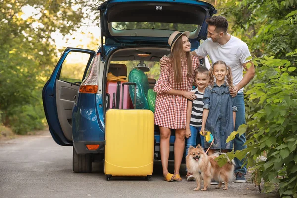 屋外で荷物を詰めた車の近くの幸せな家族 — ストック写真