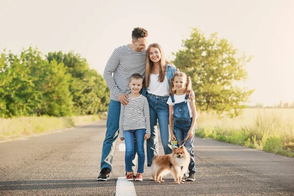 Happy family with dog on road — Stock Photo, Image