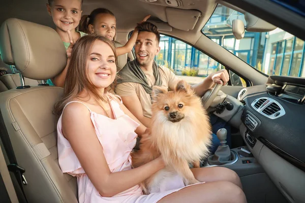Família feliz com cão viajando de carro — Fotografia de Stock
