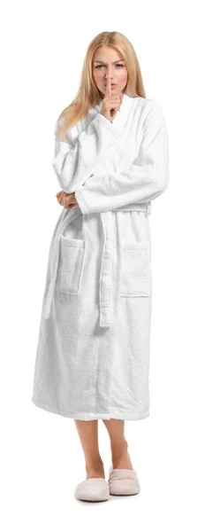 Beautiful young woman in bathrobe showing silence gesture on white background — Stock Photo, Image