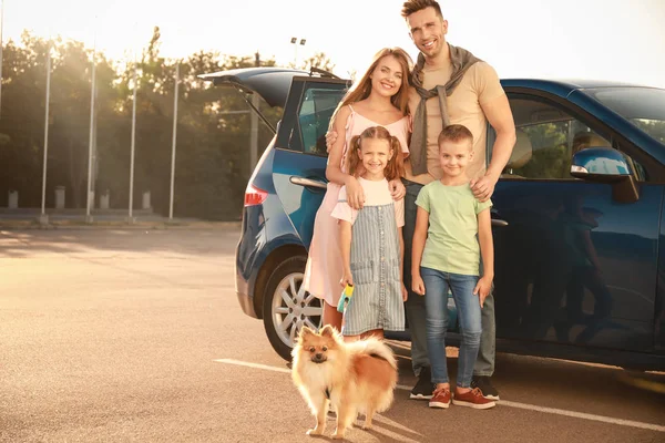 Família feliz com cão perto do carro ao ar livre — Fotografia de Stock