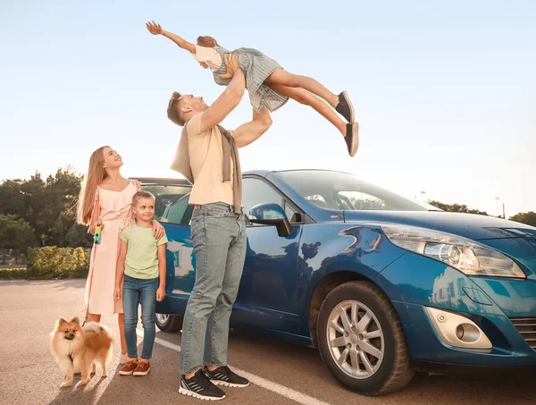 Gelukkige familie met hond in de buurt van auto buitenshuis — Stockfoto