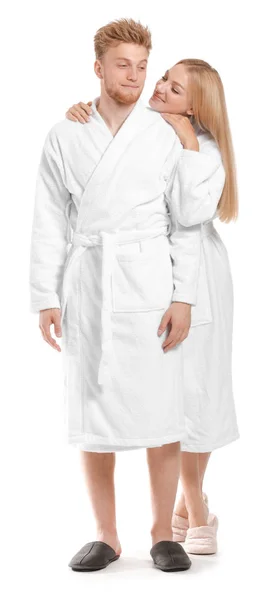 Happy young couple in bathrobes on white background — Stock Photo, Image