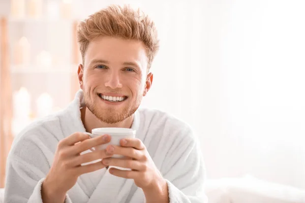 Hombre joven en albornoz bebiendo café en casa — Foto de Stock