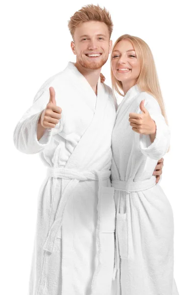 白い背景に親指を示すバスローブで幸せな若いカップル — ストック写真
