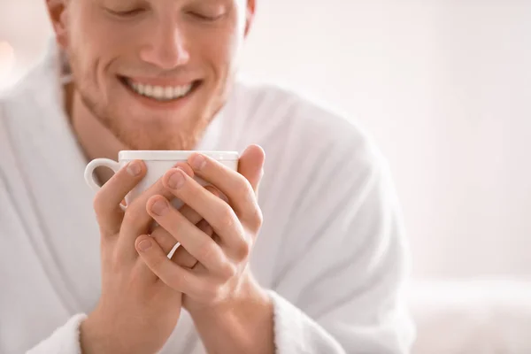 Junger Mann im Bademantel trinkt zu Hause Kaffee — Stockfoto