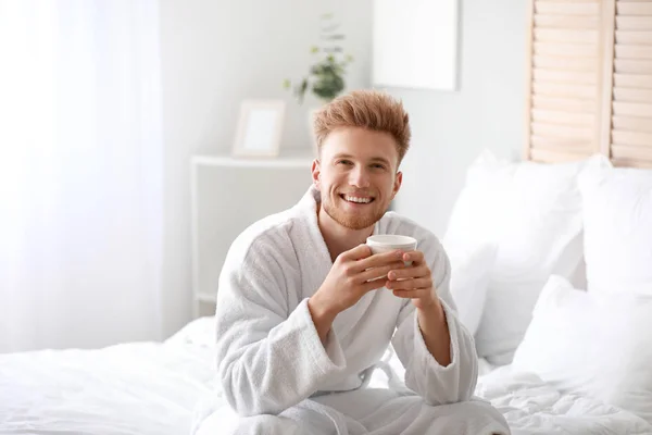 Morning of young man drinking coffee in bedroom — Stock Photo, Image