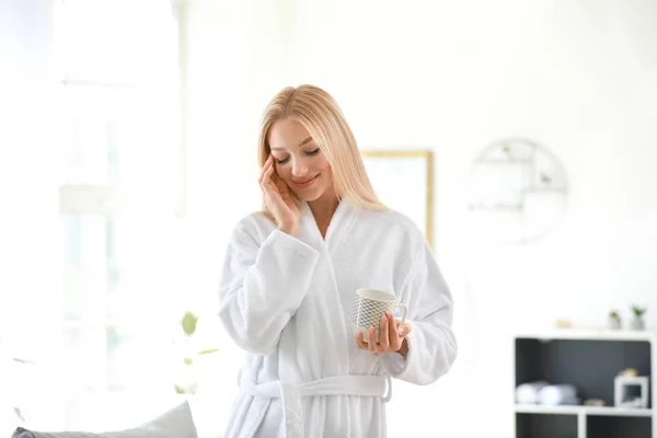 Утром молодая женщина пьет кофе дома — стоковое фото