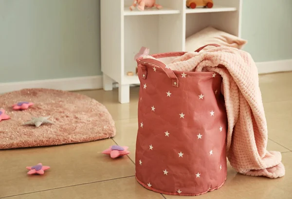 Basket with plaid on floor in room — Stock Photo, Image