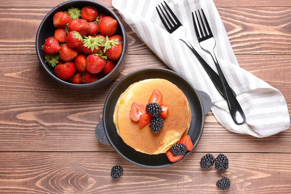 Leckere Pfannkuchen mit Beeren auf Holztisch — Stockfoto